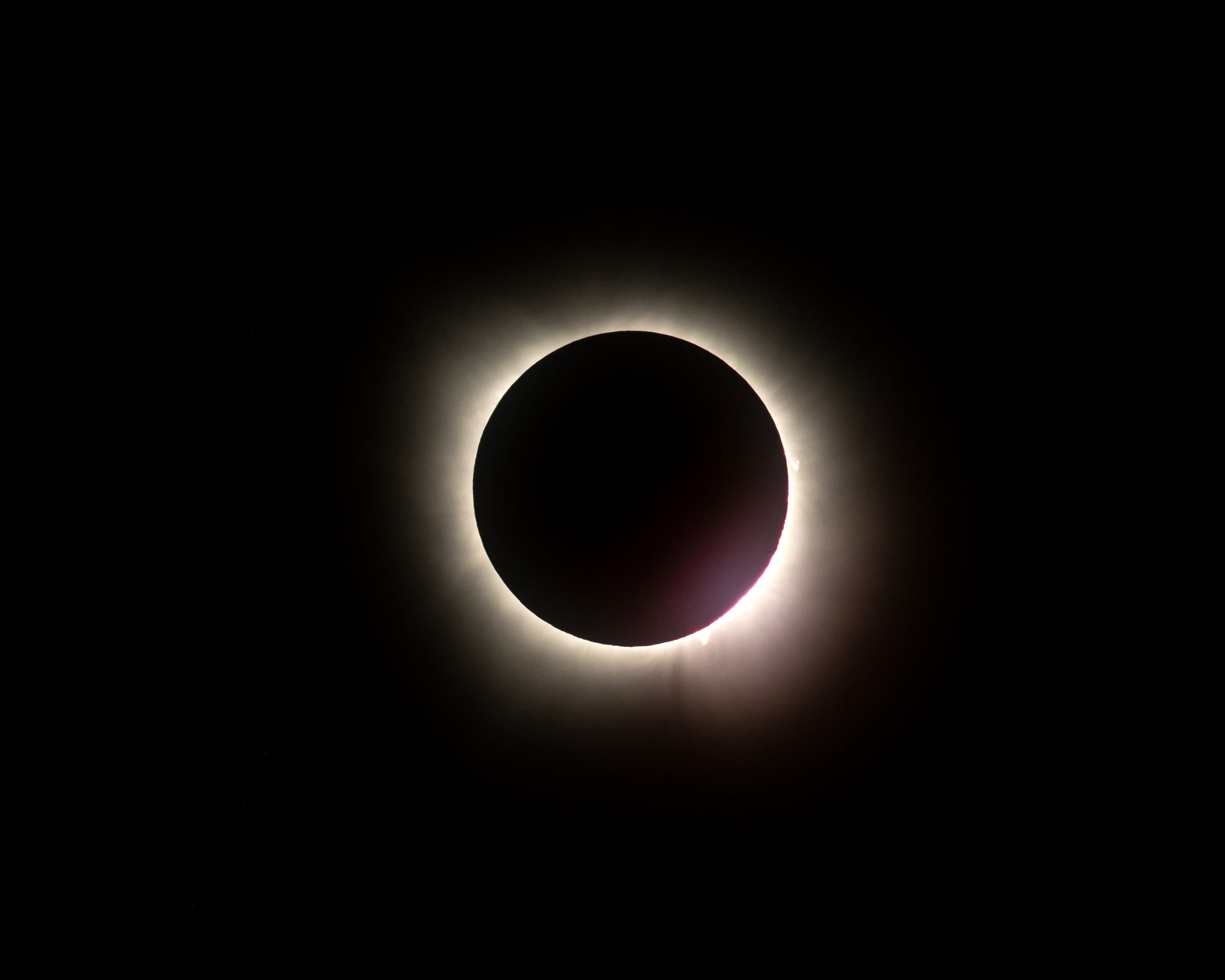 Totalité — couronne solaire au-dessus de l'horizon